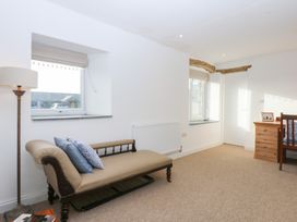 A living room with a sofa and lamp at Yr Hen Felin Dyffryn Ardudwy