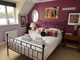A bedroom with a metal bed and artwork at 20 Keay Heights St Austell