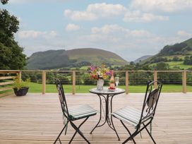 A table with chairs and flowers on a patio at Caban Tirion Dinas Mawddwy near Dolgellau