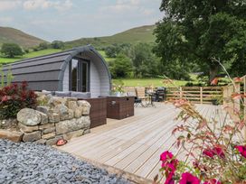 An outdoor area with a log cabin and patio furniture at Caban Tirion in Dinas Mawddwy near Dolgellau