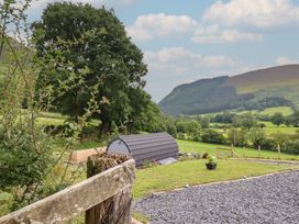 An outdoor area with a garden shed and mountains at Caban Tirion in Dinas Mawddwy near Dolgellau