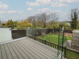 A deck with a glass railing overlooking a garden at The Swanage Rail Lookout in Swanage