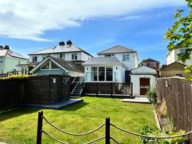 A garden with grass and a wooden shed at The Swanage Rail Lookout in Swanage