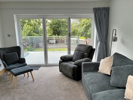 A living room with a sofa and chairs and sliding doors at The Swanage Rail Lookout in Swanage