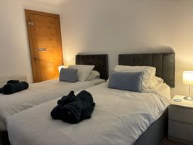 A bedroom with two beds and a lamp at The Swanage Rail Lookout in Swanage