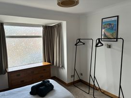 A bedroom with a window, dresser and clothes racks at The Swanage Rail Lookout in Swanage