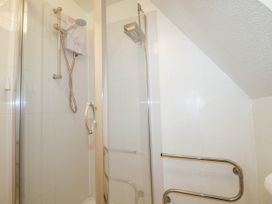 A shower cubicle with glass doors and a wall-mounted showerhead at Chalet 58 - The Beach House in Kingsdown