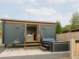 An outdoor area with a hot tub and seating at Dam View Shepherds Hut Upper Bwlch near Rhayader