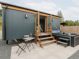 An outdoor area with steps leading to a hut and hot tub at Dam View Shepherds Hut Upper Bwlch near Rhayader