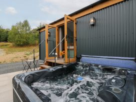 An outdoor area with a hot tub and seating at Dam View Shepherds Hut Upper Bwlch near Rhayader