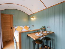 A snug with a bed and table set for breakfast at Dam View Shepherds Hut Upper Bwlch near Rhayader