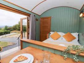 A bedroom with a bed and table at Dam View Shepherds Hut Upper Bwlch near Rhayader