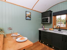 A kitchen with a table and plates at Dam View Shepherds Hut Upper Bwlch near Rhayader