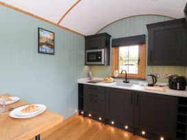 A kitchen with a dining table and croissants at Dam View Shepherds Hut Upper Bwlch near Rhayader