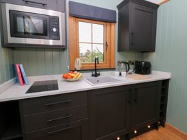 A kitchen with a sink and microwave at Dam View Shepherds Hut Upper Bwlch near Rhayader