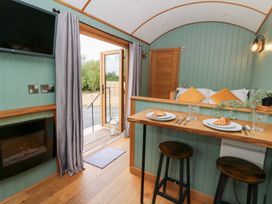 A kitchen with a table and chairs at Dam View Shepherds Hut Upper Bwlch near Rhayader