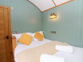 A bedroom with a bed and pillows at Dam View Shepherds Hut Upper Bwlch near Rhayader