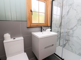 A bathroom with a toilet, sink, and shower at Dam View Shepherds Hut Upper Bwlch near Rhayader
