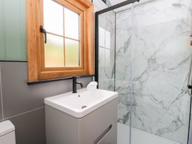 A bathroom with a sink and shower at Dam View Shepherds Hut Upper Bwlch near Rhayader