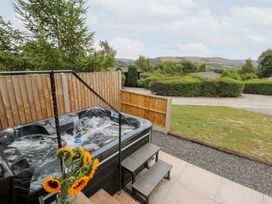 An outdoor area with a hot tub and flowers at Dam View Shepherds Hut Upper Bwlch near Rhayader