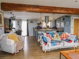 A living room with a sofa and kitchen island at Coogee View in Maenygroes near New Quay