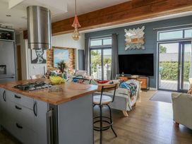 A kitchen island with a stove in a living room at Coogee View in Maenygroes near New Quay