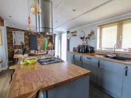 A kitchen with a stove, sink and refrigerator at Coogee View in Maenygroes near New Quay