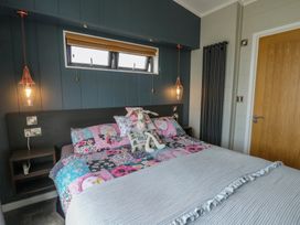 A bedroom with a colorful bed and bedside table at Coogee View in Maenygroes near New Quay