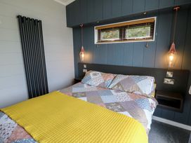 A bedroom with a bed and light fixtures at Coogee View in Maenygroes near New Quay
