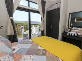 A bedroom with a bed and closet at Coogee View in Maenygroes near New Quay