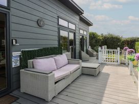 An outdoor area with a sofa and lounge chairs at Coogee View in Maenygroes near New Quay