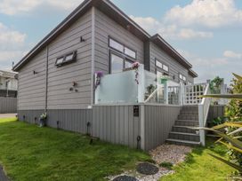 A house with a deck and steps at Coogee View in Maenygroes near New Quay