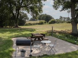 An outdoor space with a picnic table and grill at Hollie in Raglan