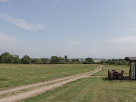 An outdoor view with a path and seating area at Poppy Raglan