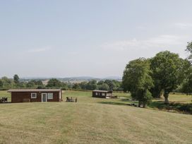 An outdoor area with log cabins and trees at Poppy in Raglan