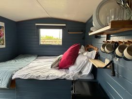 A bedroom with a bed, shelf, and window at Acres Meadow in Maiden Newton