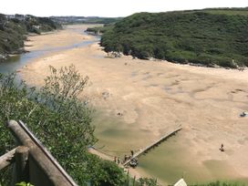 A beach scene with people and a river at Tidal View in Newquay