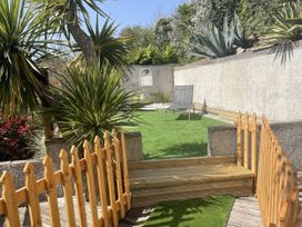 A garden with plants and a chair at Tidal View in Newquay