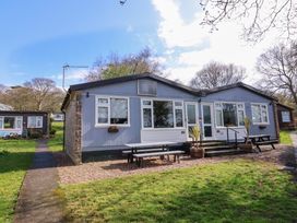 A single-story building with picnic tables outside on a grassy area at Number 24 The Park in Kilkhampton