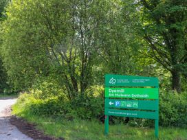 A green road sign for Dyemill with tree-covered surroundings near a roadway at Lodge 2 - 