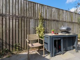 An outdoor area with a table and a chair at Stable Loft Watergate Bay