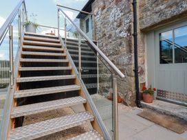 Stairs leading to a door with potted plants at Stable Loft Watergate Bay