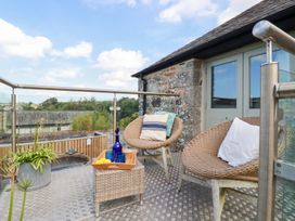 A balcony with chairs and a table at Stable Loft in Watergate Bay