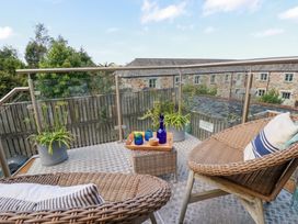 A balcony with chairs and a table at Stable Loft in Watergate Bay