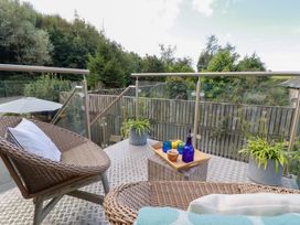 An outdoor terrace with seating and table at Stable Loft in Watergate Bay