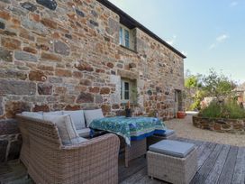 An outdoor seating area with a couch and table at Stable Loft in Watergate Bay