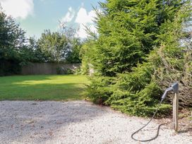 A garden with grass and trees at Stable Loft in Watergate Bay