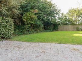 A garden with grass and trees at Stable Loft in Watergate Bay