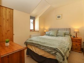 A bedroom with a bed a wooden wardrobe and a wooden chest of drawers at Ty Pili Pala in Betws-Y-Coed