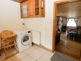 A kitchen with a washer and high chair at Harbour High Annex in Fishguard